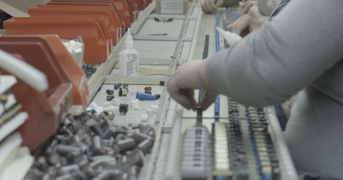 Workers hands manually assemble Electronic parts