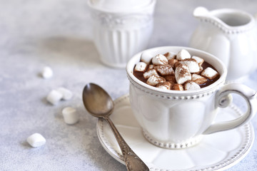 Hot chocolate with mini marshmellow in a white vintage cup.