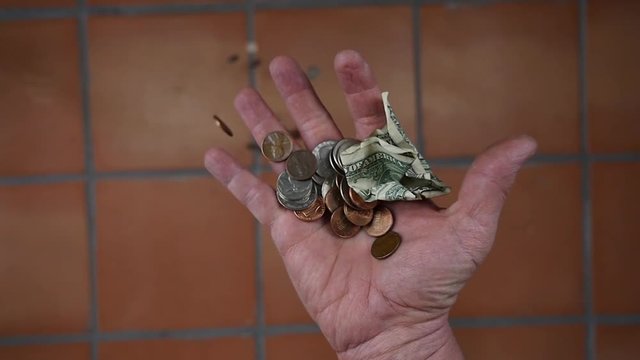 Money falling from a man's hand in slow motion