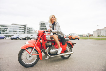 Obraz na płótnie Canvas Blonde girl on a red motorcycle