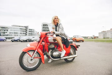 Foto op Plexiglas Blonde girl on a red motorcycle © OlgaChan