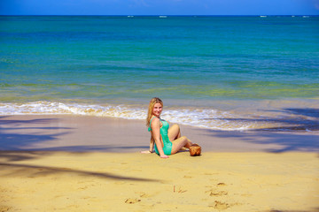 Fototapeta na wymiar Girl with coconut sitting on the beach