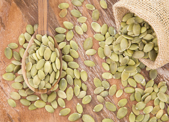 Pumpkin seeds on the wooden background