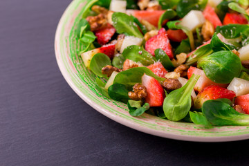 Salad with strawberry, spinach, walnuts and goat cheese