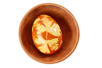 Colorful decorated easter egg in ceramic bowl on white