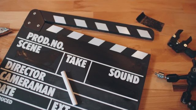  Movie slate and gadget on wooden desk. 4K UHD video.