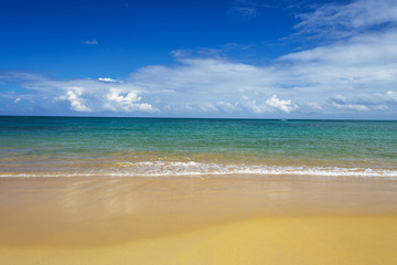 sea surf on the beach. Sand, sea, blue sky and white clouds