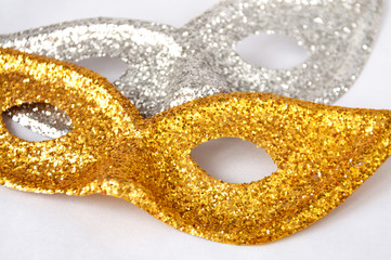 Gold and silver theatrical masks on a light background