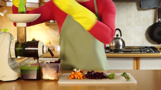 Woman adding different vegetables to juicer maker. Housewife in kitchen making raw juice, preparing nutritious drink. Healthy eating, vegetarian food, dieting concept.Timelapse 4K ProRes HQ codec