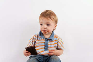 Cute toddler eating a chocolate bar