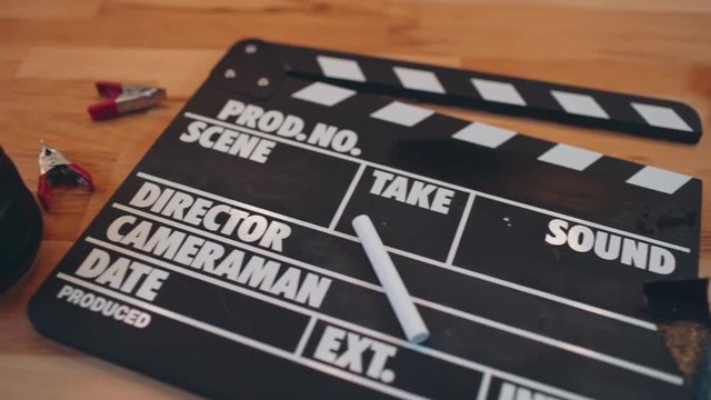 Movie slate and gadget on wooden desk. 4K UHD video.