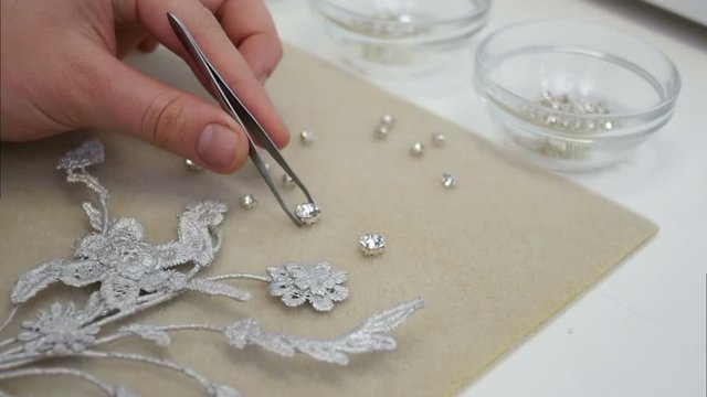 Master takes diamond in tweezers and puts it on the jewellery