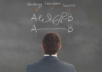 Businessman looking at business terms on chalkboard
