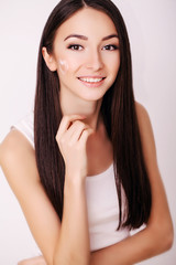 Beautiful Young Woman with Clean Fresh Skin touch her face . Facial treatment . Cosmetology , beauty and spa .