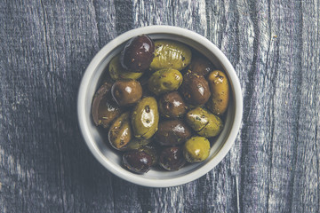 Vintage style bowl of olives on wood 