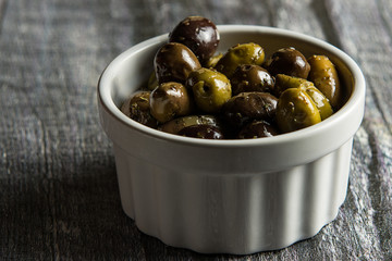 Small bowl of a variety of olives on wood
