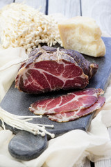 Homemade cured meat. Capocollo. Dried cured pork. Coppa sliced on pieces. Aged pork meat. Charcuterie.