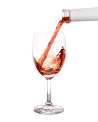 Pouring red wine into glass isolated on white background.