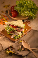 fresh made Tuna Sandwich on Wooden table in Golden Light. selective focus