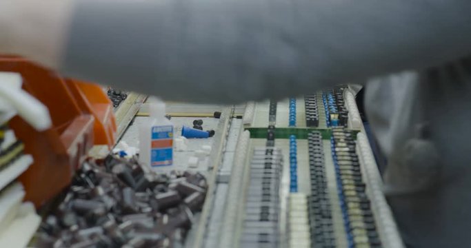 Workers hands manually assemble Electronic parts