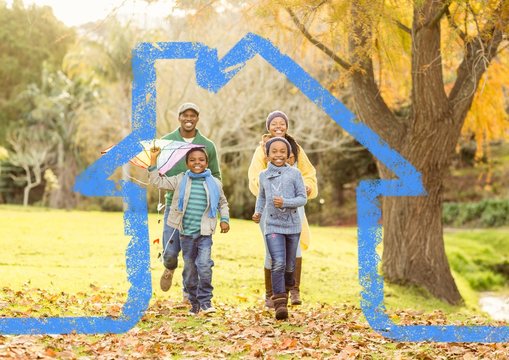 Family Running In The Park Against House Outline In Background