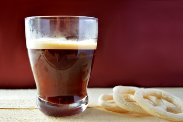 Coffee cup and some round cookies on a wood table with a red background