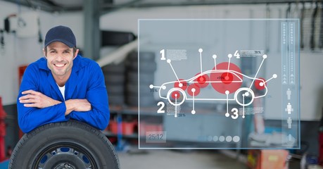 Mechanic leaning over tire against car mechanics in background