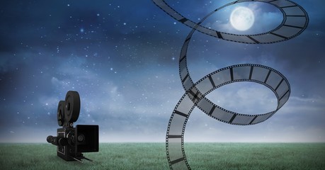 Film reel against video camera and night sky in background