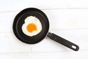 fried egg heart-shaped for breakfast on plate