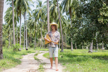 Man walking and playing music at palm trees background