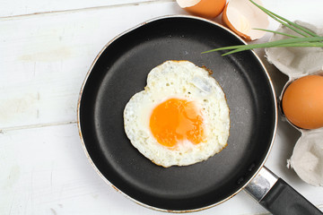 fried egg heart-shaped for breakfast on plate
