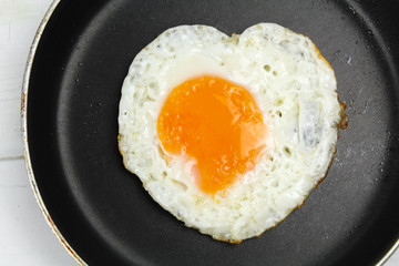 fried egg heart-shaped for breakfast on plate