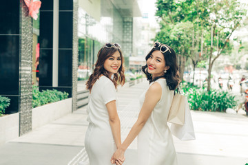 Naklejka premium Beautiful asian women with shopping bags standing outside the mall