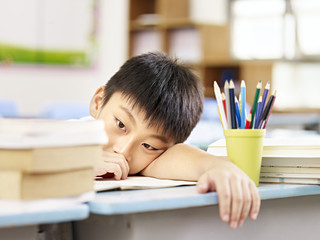 exhausted asian elementary schoolboy