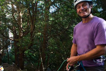 Man belays his friend while rock climbing