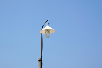 Classic street lamp against blue sky .
