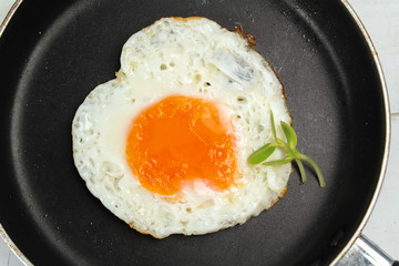 fried egg heart-shaped for breakfast on plate