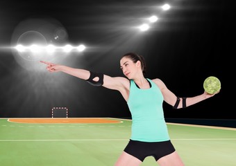 Female handball player throwing ball at handball court