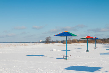 Empty beach ,Winter Beach with snow ,beach umbrellas, sunny day 
