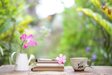 Butterfly Tree flower and books with tea cup on wooden table