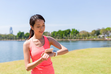 Sport woman connecting smartwatch and cellphone