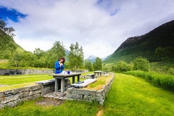 Fototapeta na wymiar Traveler woman have lunch on nature in norwegian mountains