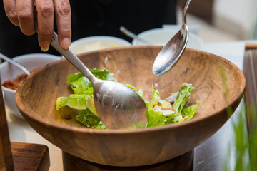 chef mixing vegetables with handmade salad dressing