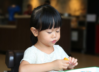 Adorable child girl eating Deep-fried Cheese Stick