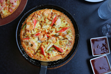 DeliciousSeafood Pizza in tray on table