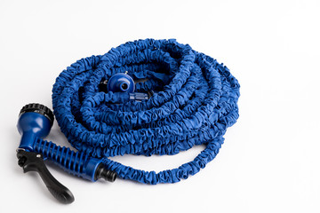 The hose of a garden hose of blue color, made of modern materials, can grow in size, stretchable