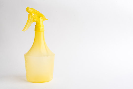 Small liquid atomizer of different colors on a white background, yellow sprayer