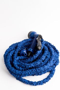 The hose of a garden hose of blue color, made of modern materials, can grow in size, stretchable