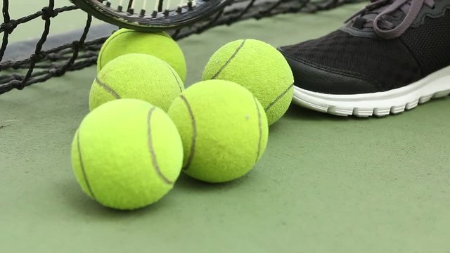 player touch Rolling tennis ball on ground at green court with net