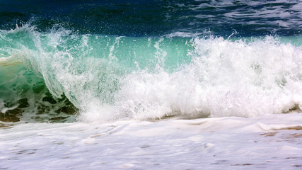 Breaking wave. Empty green wave rolls through to beach with no surfer in view